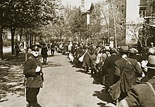 A column of people marching with luggage