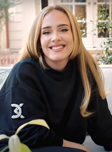 Adele in a black sweatshirt, smiling