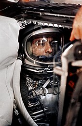 Shepard in his Mercury space suit and helmet, with tubes connected.