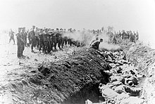 Men execute at least four Soviet civilians kneeling by the side of a mass grave