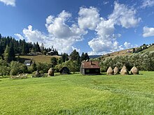 Poiana Horea, village in Beliș commune in Cluj County, Transylvania, ROMANIA - Landscape in the Apuseni Mountains (Munții Apuseni) - Farm with haystacks (Hay drying poles), church and cemetery