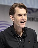A photograph of Kevin Conroy speaking at a convention