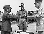 駐新幾內亞的第18軍指揮官安達二十三在簽署無條件投降條約後，向澳洲第六師（6th Division）師長霍勒·羅伯遜（Horace Robertson）交出自己的佩劍，攝於1945年9月13日。