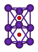 两个共面的正八面体的球棍模型。这一结构的9个顶点上的紫色球代表铷，两个八面体中心的小红球代表氧。