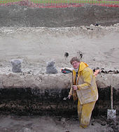 Un géoarchéologue au travail, sur le tracé de la LGV Est, devant une stratigraphie montrant des tourbes et des dépôts lacustres.