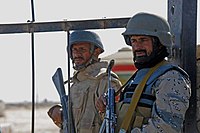 Pakistan Frontier Corps Balochistan soldier (left) and the Afghan Border Police soldier (right), wearing the Saudi blue DBDUs, guard the Durand Line's Friendship Gate, seven km southeast of Spin Boldak, Afghanistan