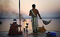 Prêtre hindou saluant le soleil au bord du Gange à Varanasi.