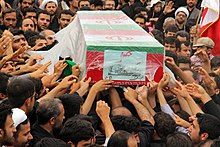 عکس از خاکسپاری یکی از کشته شدگان جنگ هشت ساله ایران و عراق، در منطقه پردیسان شهر قم (که در ادبیات جمهوری اسلامی ایران از آنان با عنوان شهید گمنام یاد می‌شود)