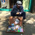 南京街头的老年商贩，仅以一折叠式木盒展示所售商品