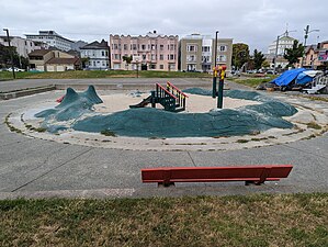 The small sand playground at Wilma Chan Park is encircled by a concrete dragon