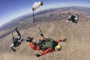 Two instructors critique a Special Forces soldier at a HALO jump course at the Yuma Proving Grounds.