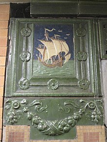 Original cartouche on the IRT platform, depicting Christopher Columbus's ship, the "Santa Maria". The cartouche is surrounded by a green carving.