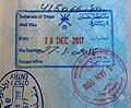 馬斯喀特國際機場的阿曼落地簽證。藍色矩形印章代表簽證與入境章。紅色圓形印章是在瓦雅雅（英语：Wajaja）陸上關口。左下角的藍色印章是在瓦雅雅的阿拉伯聯合大公國端蓋上。