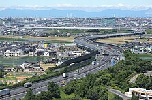 第二東名としては中京地区が最も早い開通を見たが、東京 - 名古屋 - 神戸間の国土軸を形成するのはしばらく後のことで、当面は当該地区のネットワーク構築が優先されることから[243]路線名も伊勢湾岸自動車道を称した[108]。 画像左 : 第二東名として最初の開通区間である名古屋南IC - 東海IC間（東海市名和町）。画像右 : 第二東名として先行開通した豊田東JCT以西の区間を刈谷ハイウェイオアシスから望む。画像奥の名港トリトンの主塔が垣間見えるところが第二東海自動車道の終点の名古屋港方面。