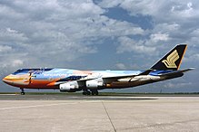 Un gros avion multicolore, au roulage, montre son côté gauche.