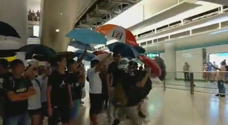 一群市民利用雨傘作保護，當時民主黨立法會議員林卓廷亦在場