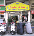 一家由泰國人在香港經營的泰國菜館，門口的招牌上的店名有泰文、中文和英文對照。