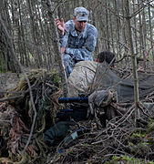 A Special Forces Master Sergeant gives pointers to two other Special Forces soldiers at a NATO sniper course in Germany.