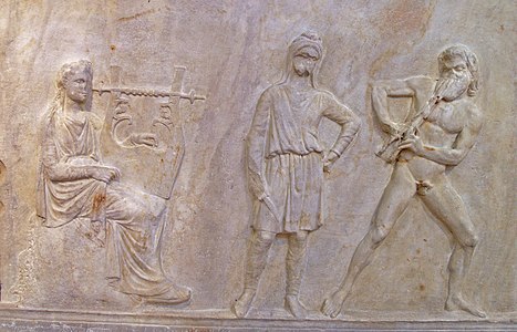 Le concours entre Apollon et Marsyas. Base de Mantinée, œuvre de l'atelier de Praxitèle, IVe siècle av. J.-C., musée national archéologique d'Athènes.