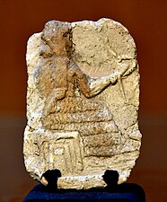 Divinité (Shamash ?) sur son trône tenant l'anneau/cercle et le bâton. Plaque en terre-cuite de l'époque paléo-babylonienne. Musée de Souleimaniye.