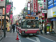 商店街を徐行するバス
