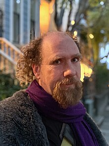 Photographic portrait of Peter Eckersley on a San Francisco Street at twilight.