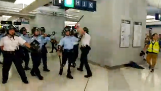 警員手持警棍後退和離開港鐵站